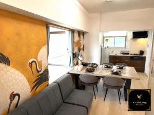 a living room with a couch and a table with chairs at K-ART Stay Shinsakae2 in Nagoya