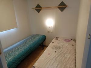 a small room with a bed and a light at Thery location 17 in Saint-Pierre-dʼOléron
