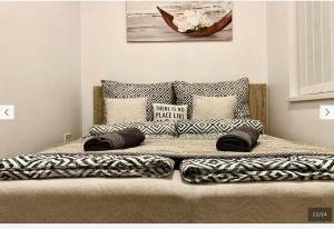 a bed with pillows on it in a bedroom at Downtown Cosy-Rooms in Miskolc