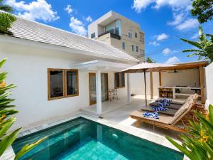 a villa with a swimming pool and a house at Villa Marieta - Two Bedrooms Private Villa in Kuta Lombok