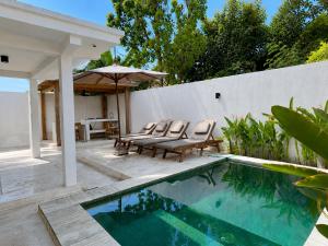 a backyard with a swimming pool and chairs and a fence at Villa Marieta - Two Bedrooms Private Villa in Kuta Lombok