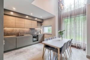 a kitchen with a white table and chairs at Imanta Garden Townhouses in Riga
