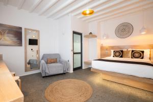 a bedroom with a bed and a chair in a room at Double Mini Suites Adults Only in Ano Mera