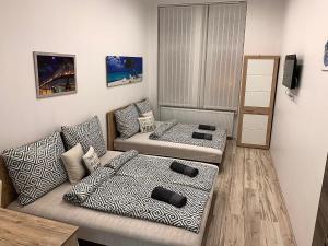 a living room with two couches and a couch at Downtown Cosy-Rooms in Miskolc