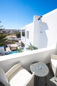 a balcony with chairs and a table and a view at Double Mini Suites Adults Only in Ano Mera