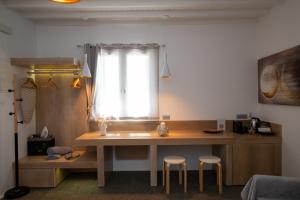 a kitchen with a table with two stools and a window at Double Mini Suites Adults Only in Ano Mera