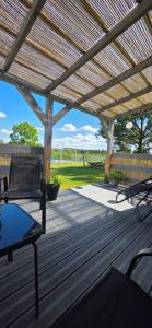 a wooden pergola with benches and a table on a deck at W ładnym polu n1 in Ruciane-Nida