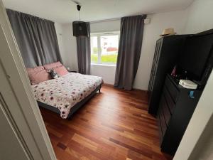 a room with a bed and a tv and a window at Apartment close to city center in Haugesund
