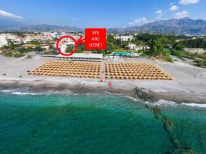 a sign that says we are here on a beach at DaMa s Apartment on the beach in Giardini Naxos