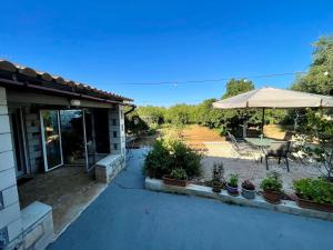 a patio with an umbrella and a table and chairs at Mersini Village in Milonianá