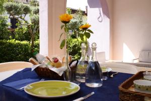 a table with a blue table cloth and a vase with flowers at Villa Margot in Agropoli
