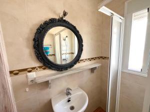a bathroom with a mirror and a sink at Casa Maena in Cómpeta +14 photos