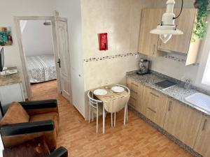 a kitchen with a small table and a kitchen with a bed at Casa Maena in Cómpeta