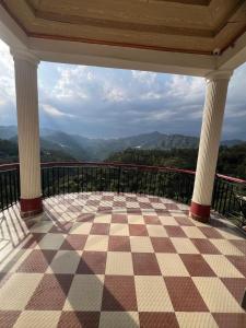 a checkered floor on a balcony with a view at THE PINE STAy in Chail