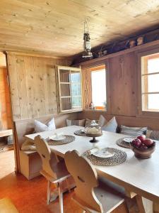 a dining room with a large white table and chairs at Naturlodge Gadestatt in Loch