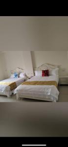two beds sitting next to each other in a bedroom at Shanhai B&B in Jinning