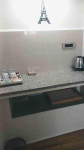 a kitchen with a counter top with a table and the eiffel tower at Wonderville Ensuite Rooms in Cuncolim