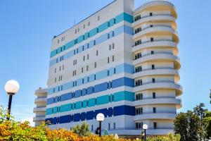 a tall white building with blue windows at Mera Maris in Cap Aurora