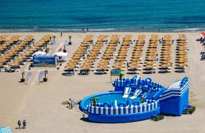 a beach with a bunch of chairs and a water park at Mera Maris in Cap Aurora