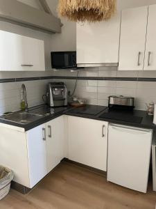 a kitchen with white cabinets and a sink at Appartement in Arles