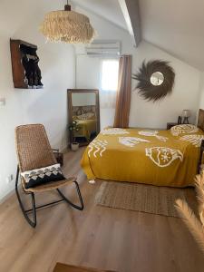 a bedroom with a bed and a chair and a mirror at Appartement in Arles