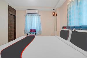 a bedroom with a large bed and a red chair at Super Collection O Halcyon SS Grand in Hyderabad