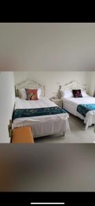two beds in a bedroom with white walls at Shanhai B&B in Jinning