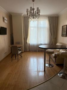 a living room with a table and a couch and a dining room at Аркадия, Генуэзская in Odesa