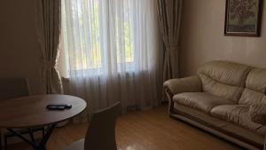 a living room with a couch and a table and a window at Аркадия, Генуэзская in Odesa
