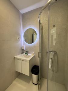 a bathroom with a sink and a shower with a mirror at Vengo Apartments in Kotor