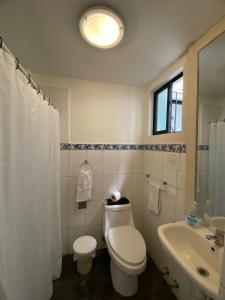 a white bathroom with a toilet and a sink at Hotel Andalucía in Arica +26 photos