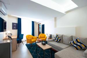 a living room with a couch and yellow chairs at Premium Inn Mombasa City in Mombasa