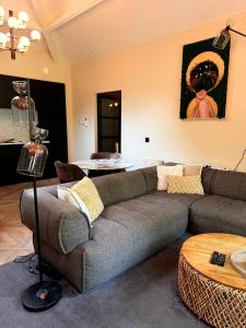 a living room with a couch and a table at Berg en Bos Suite met luxe jacuzzi in Apeldoorn