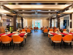 a dining room with tables and orange chairs at Ambassador Hotel Eupen in Eupen