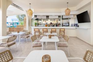 a restaurant with tables and chairs and a bar at Aeloria Boutique Hotel Corfu in Benitses