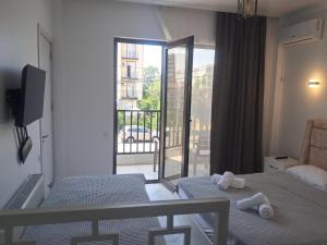 a bedroom with two beds and a view of a balcony at ilios in Kobuleti