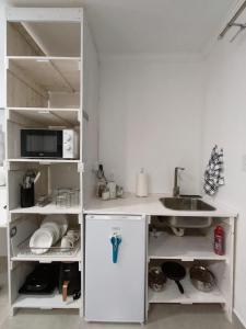 a white kitchen with a sink and a refrigerator at Wag-n-Bietjie in Centurion