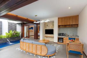 a kitchen and living room with a couch and a table at THE SAND Suites & Villas in Ngurah Rai International Airport