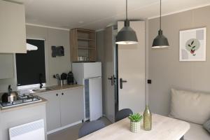 a small kitchen with a table and a refrigerator at Sideschlee Chalet aan het water in Wintger