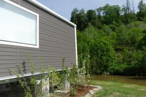 a building with a window next to a body of water at Sideschlee Chalet aan het water in Wintger