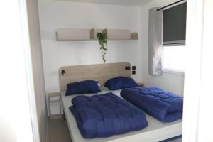 a bedroom with two beds with blue pillows at Sideschlee Chalet aan het water in Wintger
