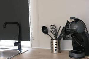 a kitchen counter with a coffee maker and utensils at Sideschlee Chalet aan het water in Wintger