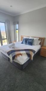 a large bed in a bedroom with a window at Casa Del Sol in Riwaka