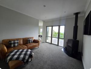 a living room with a couch and a stove at Casa Del Sol in Riwaka +5 photos