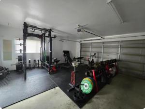 a garage with a gym with bikes and machines at Casa Del Sol in Riwaka