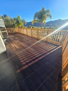 a deck with a wooden fence and a water hose at Casa Del Sol in Riwaka