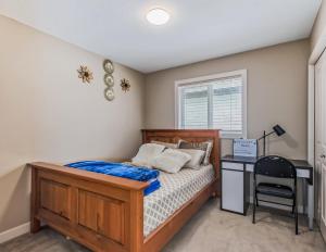 a bedroom with a wooden bed and a desk at Rome, Sweet Home in Calgary