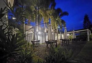 a group of tables and chairs with umbrellas at night at Cleon Villas Pension in Puerto Princesa City +20 photos