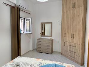 a bedroom with a wooden dresser and a mirror at Dimitra's House in Kefalos