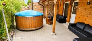 a large wooden barrel with a blue top on a patio at Vilimu Sodyba - White Hall in Kriukai +6 photos